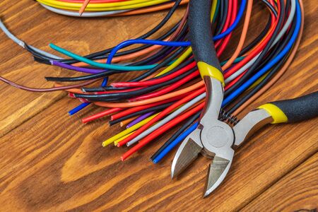 Electrician tool and wires on vintage wooden boards for repairing energized systems or...