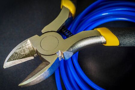 Pliers tool and wires for electrician close up, service and repairing concept on blackの写真素材