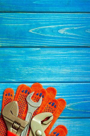 Set of tools and work gloves for plumbers on blue wooden boardの写真素材