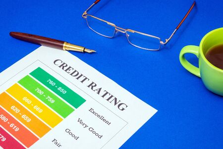 Credit rating form on the blue office desk with glasses and stylish pen, business ideaの写真素材