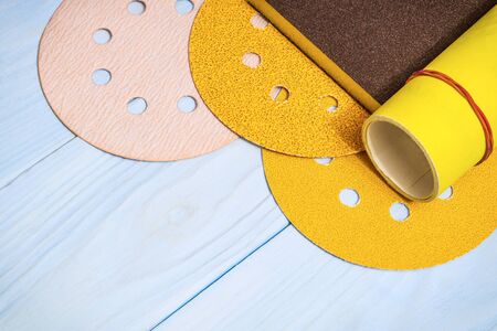 Set of abrasive tools and yellow sandpaper on wooden blue boards
