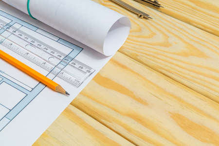 Accessories and drawing tools lie on building project or wooden boards