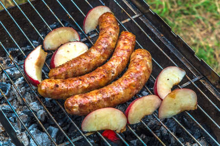 Assorted delicious grilled meat with vegetables over the coals on a barbecueの写真素材