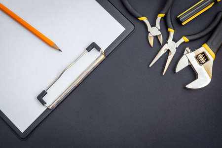 Tablet with a blank sheet of paper for drawing up work plan and tools