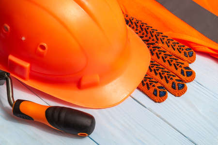 Master builder orange protective equipment stacked on blue boards before workの写真素材