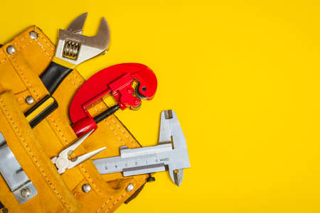 Set of tools in suede bag on yellow background prepared by the plumber mastermaster electrician...