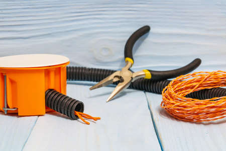 Tools and accessories used in electrical installation or repair on blue wooden workshop table