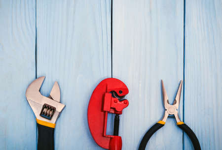 Set of tools for plumbers or a master builder on wooden blue boards with advertising space