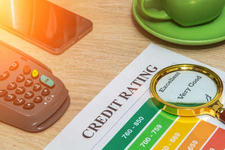 Credit rating form on office desk with magnifying glass and payment terminal. Business idea.の写真素材