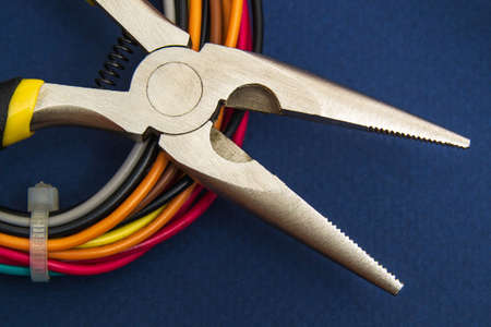 Wire cutters or pliers and wires close up on dark blue background.の写真素材