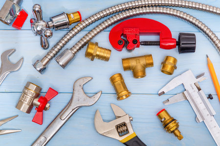 Necessary set of tools and spare parts for plumbers on blue wooden background.の写真素材