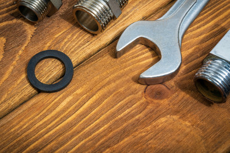 Brass fittings and wrench on vintage boards close up. Plumbing equipment repair idea conceptの写真素材