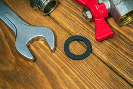 Brass fittings and wrench on vintage boards close up. Plumbing equipment repair idea conceptの写真素材