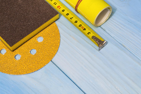 Set of abrasive tool and yellow sandpaper on blue wooden boardsの写真素材