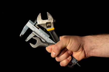 The hand of the master holds a set of tools for repairing plumbingの写真素材