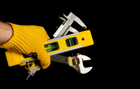 The hand of the master holds set of tools for repairing or construction