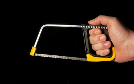 Hand wizard holding a hacksaw with clipping path on black isolated backgroundの写真素材