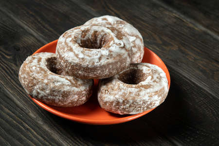 Homemade round gingerbread cookies with icing in a orange plate. Idea for a delicious breakfast or dinner. Top viewの写真素材
