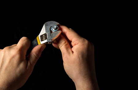 The master tighten the nut with a adjustable wrench in the bolt close upの写真素材