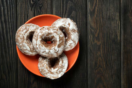Homemade round gingerbread cookies with icing in a orange plate. Idea for a delicious breakfast or dinner. Top viewの写真素材
