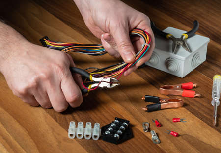 Electrician cuts the wire with diagonal pliers. Working environment on the workshop table