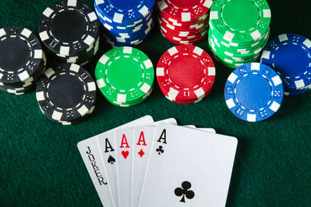 Poker cards with five of a kind highest combination in the game. Chips and money on the green table...