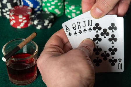 Poker cards with royal flush combination. Close up of gambler hand is holding playing cards in poker...