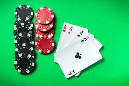 A poker game with a four of a kind or quads hand. Chips and cards on the green tableの写真素材