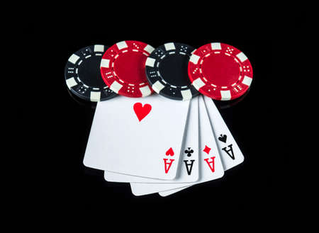 Poker game with a four of a kind or quads combination. Chips and cards on the black table in poker...