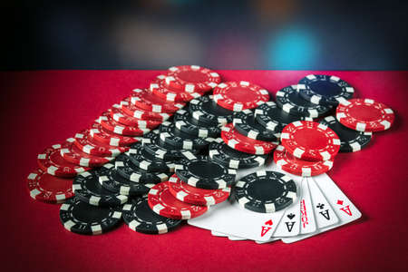 Poker game with five of kind combination. Chips and cards on the red table. Successful and maximum...