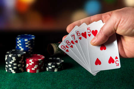 Poker cards with straight flush combination in the game. Close-up of a gambler hand is holding...