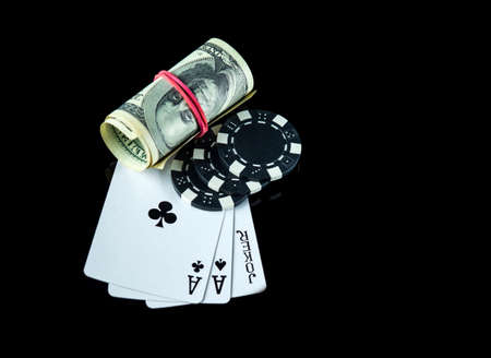Poker game with a three of a kind or set combination and dollars. Chips and cards on the black table in poker club. Free advertising spaceの写真素材