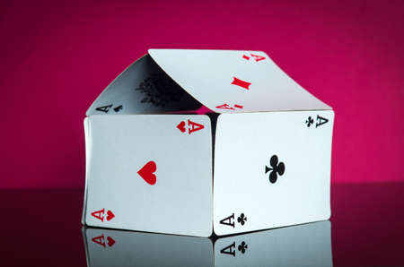 House of cards with aces on a red background. The idea of winning a cottage or a mansion