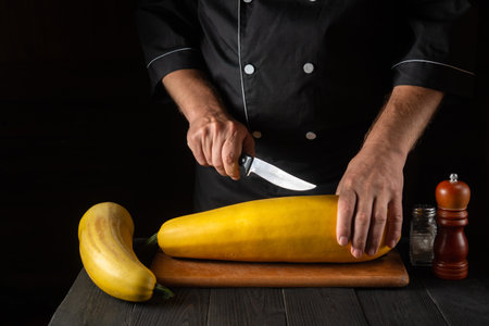 The chef cuts ripe yellow marrow with a knife. Fried zucchini is a great diet for breakfast or lunch. Work environment on the kitchen table of the restaurant. Free advertising spaceの写真素材