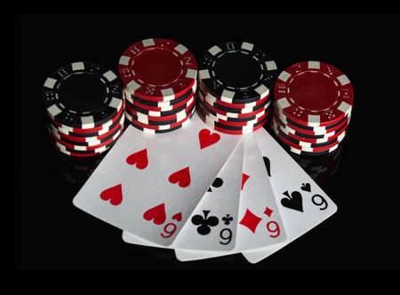 Poker game with four of a kind or quads combination. Chips and cards on the black table. Successful...