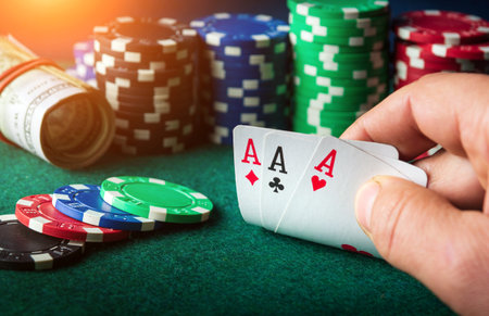 Poker cards with three of a kind or set combination. Close up of gambler hand takes playing cards in...