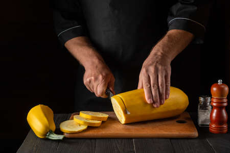 The chef cuts ripe yellow marrow with a knife. Fried zucchini is a great diet for breakfast or lunch. Work environment on the kitchen table of the restaurant. Free advertising space.の写真素材