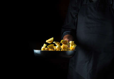 Cook prepares zucchini in a pan. Cooking vegetables healthy vegetarian food and meal on a dark background. Free advertising space.の写真素材