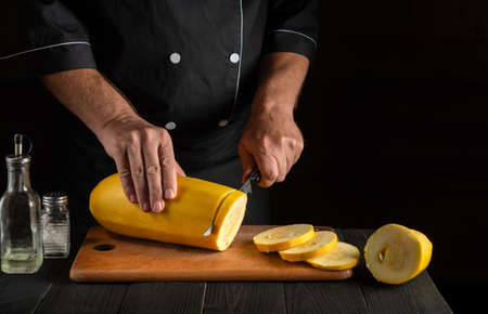 Cook cuts ripe yellow marrow with a knife. Fried zucchini is great diet for breakfast or lunch. Work environment on the kitchen table of the restaurant. Free advertising space.の写真素材