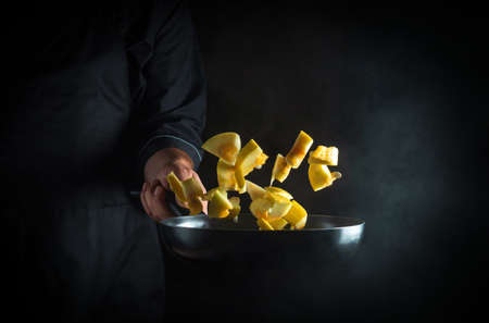 The chef prepares zucchini in a pan. Cooking vegetables healthy vegetarian food and meal on a dark...