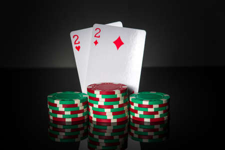 Poker game with one pairs combination. Chips and cards on dark table. Successful and winの写真素材