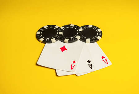 Poker game with three of a kind or set combination. Chips and cards on yellow table. Successful and win four sevensの写真素材
