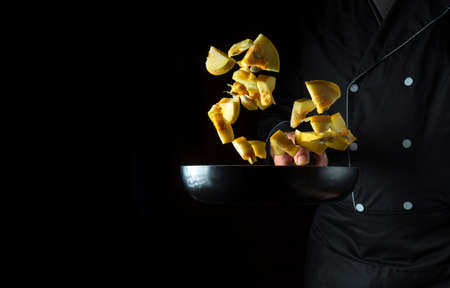 Chef prepares zucchini in a pan. Cooking vegetables healthy vegetarian food and meal on a dark backgroundの写真素材