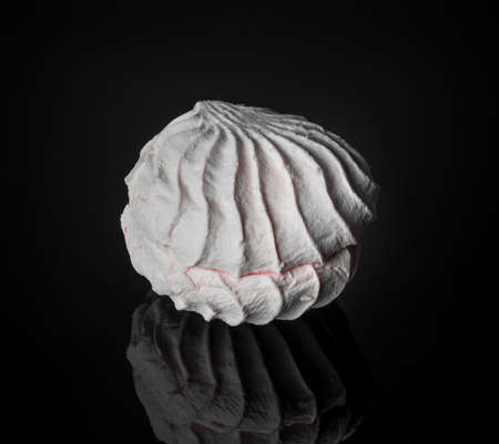 Aerial dessert marshmallow. One sweet pieces of marshmallow on a black background. Dessert meringue