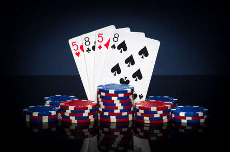 Playing cards in poker game with two pairs combination. Chips and cards on black table. Successful...