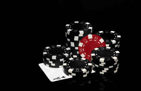 Chips and ace cross on the black table in the casino. Fortune or success in the game of poker.