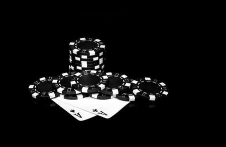 Chips and cards on the black table. Poker cards with one pair combination in casino. Luck or fortune in the game of pokerの写真素材