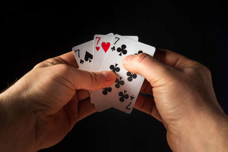 The player hands hold playing cards with a winning combination of three of a kind or set. Success at...