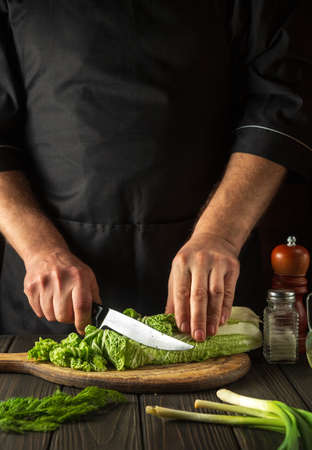 Chinese cabbage sliced on a cutting board in a restaurant kitchen. The head chef prepares a delicious salad for breakfast.の写真素材