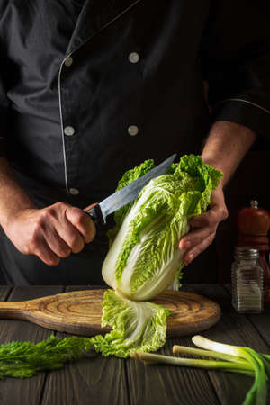 Napa cabbage salad preparation. Chef while working in the restaurant kitchen. Diet breakfast or dinner idea.の写真素材